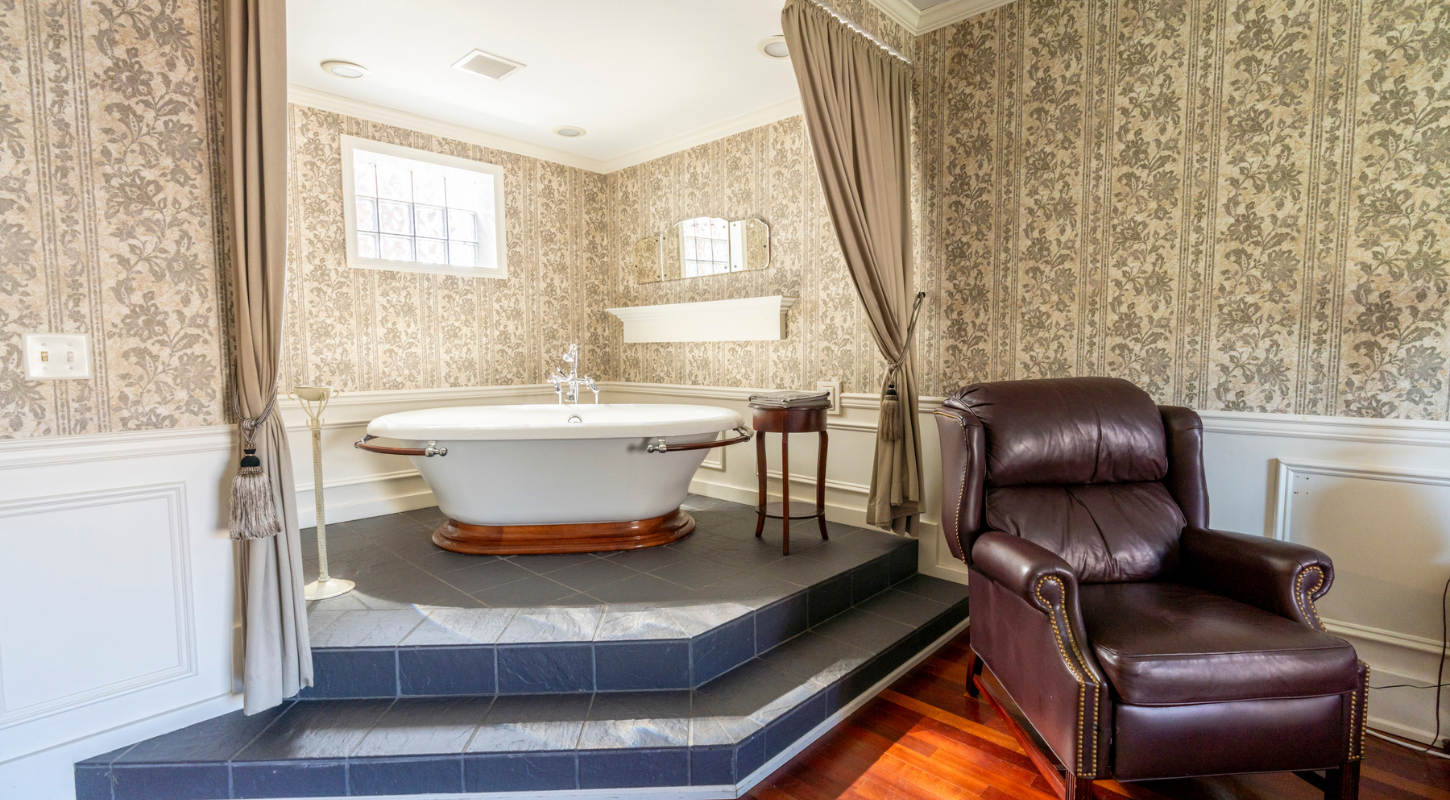 Elegant soaking tub in a warmly lit bathroom, featuring classic fixtures and a relaxing ambiance