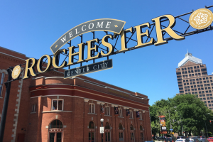 View of the entrance to downtown Rochester, featuring a prominent sign reading "Welcome" and "Rochester - Center City"